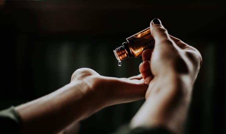 person holding amber glass bottle