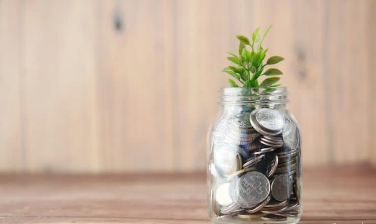 a glass jar filled with coins and a plant