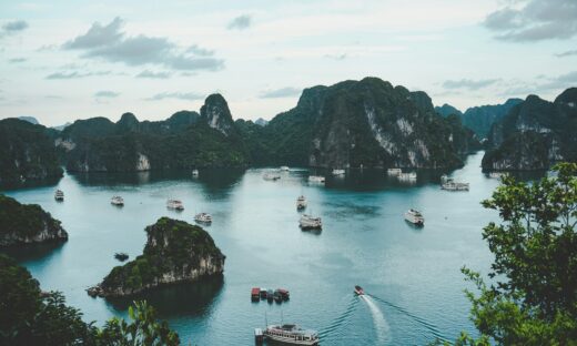 high-angle photography of boats on water near hill during daytime