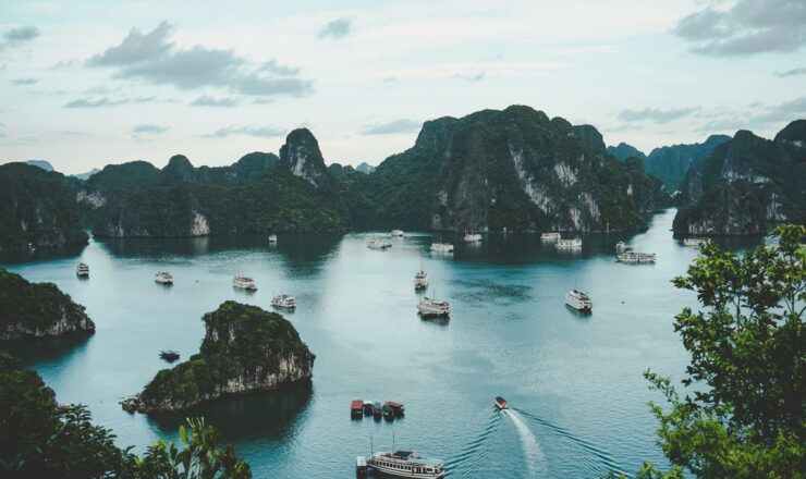 high-angle photography of boats on water near hill during daytime