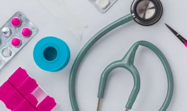 green and silver stethoscope on white envelope