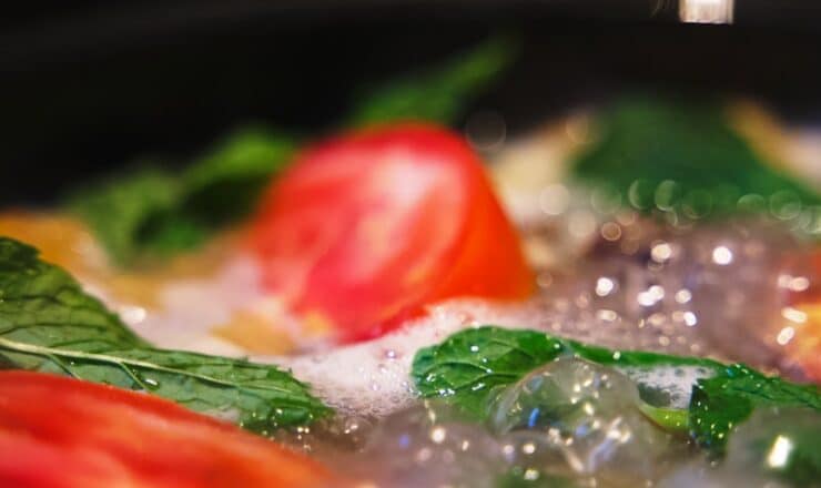 a close up of a pan of food with tomatoes and spinach