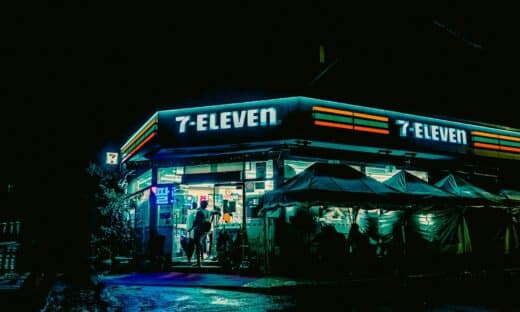 a street corner with a store lit up at night