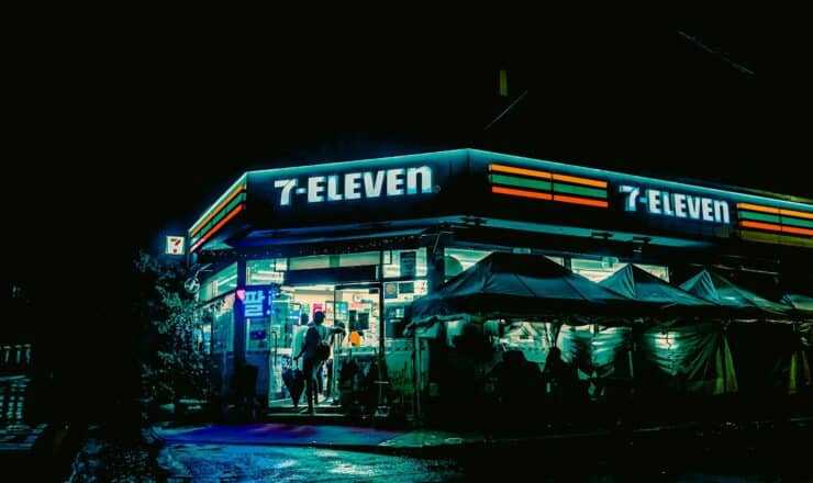 a street corner with a store lit up at night