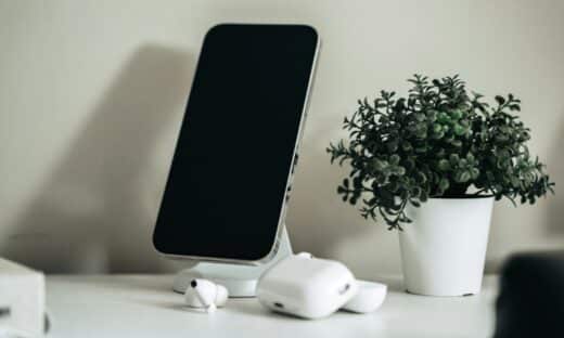 a cell phone sitting on top of a table next to a potted plant
