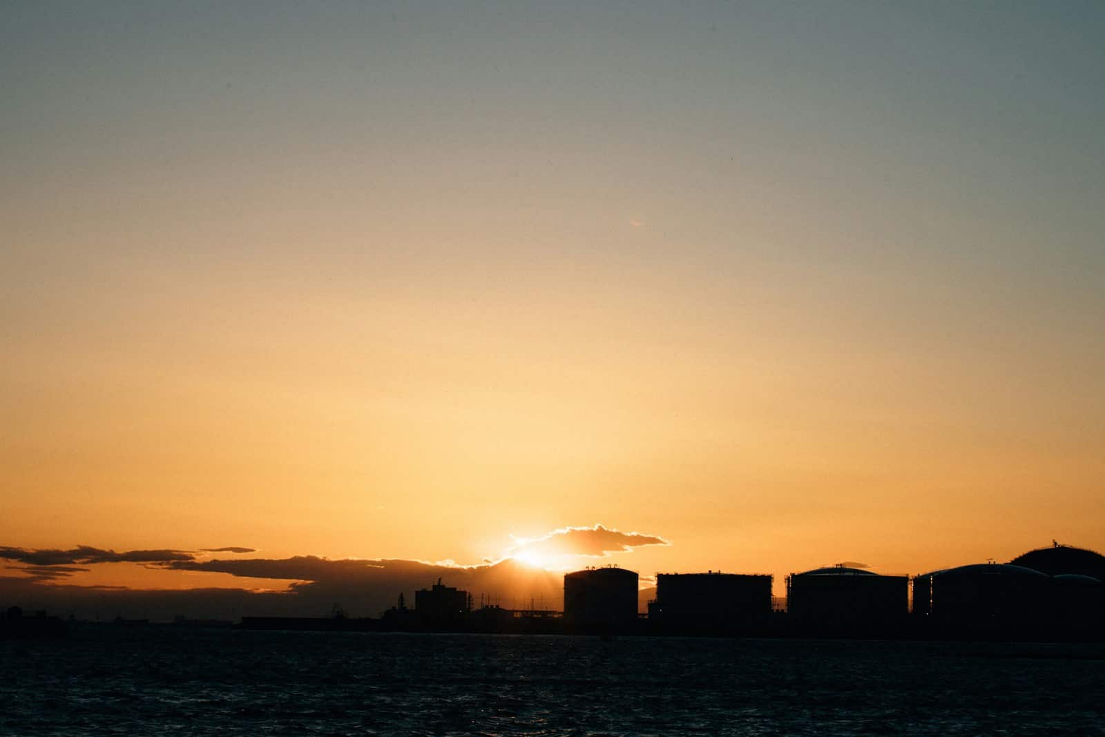 the sun is setting over a city on the water