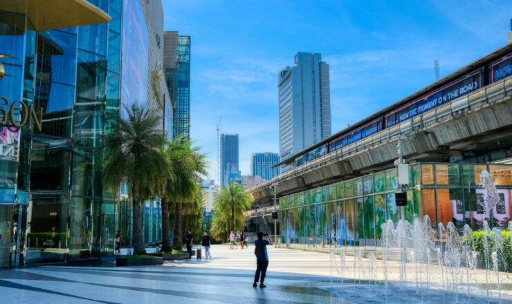 a man walking down a street next to tall buildings